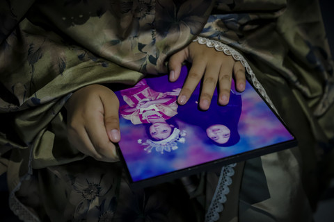 Mengenang Ibu: Kamila, memandang foto ia bersama ibunya saat berada di dalam kamar asrama Sekolah Rakyat Menengah Pertama (SRMP) 6 Jakarta. Foto: Jamal Ramadhan/kumparan