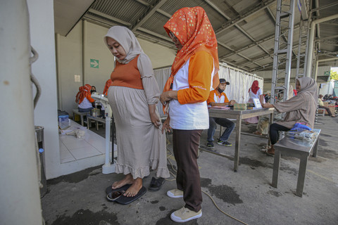 Karyawati yang hamil sedang menimbang bobotnya. Foto: Aditia Noviansyah/kumparan