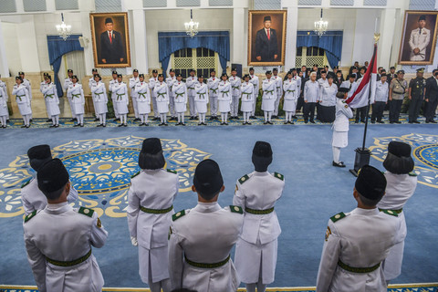 Anggota Paskibraka 2025 asal Papua Barat Ritha Lovely CF Ayomi (kanan) mencium Bendera Merah-Putih dalam upacara pengukuhan Paskibraka Tingkat Pusat 2025 di Istana Negara, Jakarta, Sabtu (16/8/2025).  Foto: Galih Pradipta/ANTARA FOTO