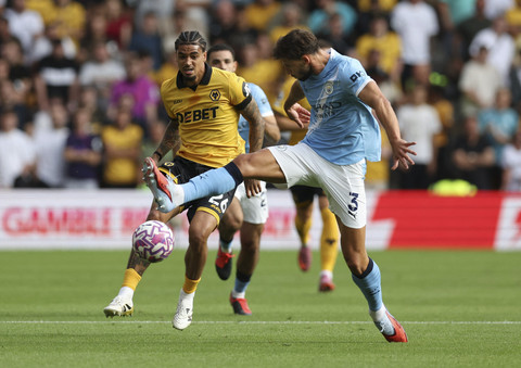 Pemain Manchester City Ruben Dias berebut bola dengan pemain Wolverhampton Wanderers Ki-Jana Hoever pada pertandingan Liga Inggris 2025/2026 di Stadion Molineux, Wolverhampton, Inggris, Sabtu (16/8/2025). Foto: Chris Radburn/Reuters