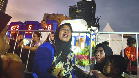 Seorang warga yang diturunkan bus pariwisata, Neti (46), datang dari Garut ke Bundaran HI, Jakarta, Minggu (17/8/2025). Foto: Thomas Bosco/kumparan