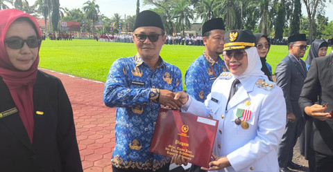 PNS BKPSDM Kabupaten Mempawah, Rudiansyah, saat menerima penghargaan Satyalancana Karya Satya 20 tahun dari Bupati Mempawah, Erlina, pada Minggu, 17 Agustus 2025.