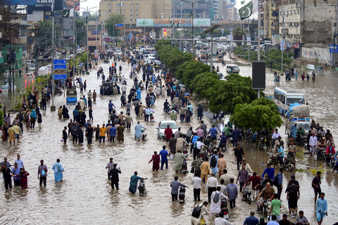 Warga berjalan melewati banjir di Karchi, Pakistan, Selasa (19/8/2025). Foto: Imran Ali/REUTERS