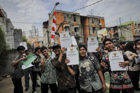 Sejumlah siswa berpose menunjukkan dokumen ijazah saat program pemutihan penundaan pemberian ijazah di SMA Islam Said Naum, Tanah Abang, Jakarta, Kamis, (21/8/2025). Foto: Jamal Ramadhan/kumparan