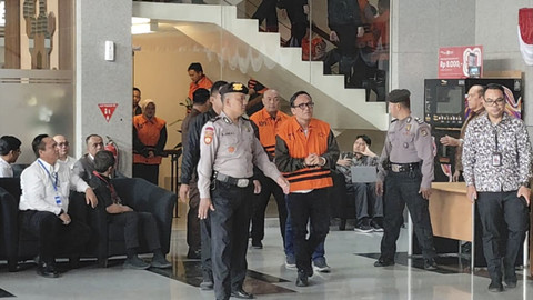 Wamenaker Immanuel Ebenezer mengenakan rompi oranye saat berjalan menuju ruang konferensi pers di Gedung Merah Putih KPK, Jakarta, Jumat (22/8/2025). Foto: Jonathan Devin/kumparan