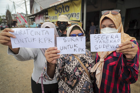 Sejumlah warga yang terdampak kebijakan naiknya pajak oleh Bupati Pati Sudewo menunjukkan surat yang akan dikirimkan ke KPK RI di Kantor Pos Tayu, Kabupaten Pati, Jawa Tengah, Jumat (22/8/2025). Foto: Iqbal Firdaus/kumparan