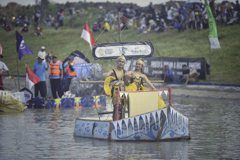 Dua peserta menari saat menaiki perahu dalam Festival Pecunan Jatitujuh 2025 di Saluran Cipelang, Kabupaten Majalengka, Jawa Barat, Sabtu (23/8/2025). Foto: kumparan