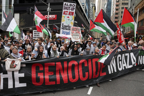 Para demonstran memegang plakat dan bendera saat mereka berpartisipasi dalam protes 'Pawai Nasional untuk Palestina' di Sydney, Australia, Minggu (24/8/2025). Foto: Hollie Adams/REUTERS