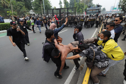 Massa mengevakuasi rekannya yang terluka saat berunjuk rasa di depan Gedung DPR RI, Jakarta, Senin (25/8/2025). Foto: Jamal Ramadhan/kumparan