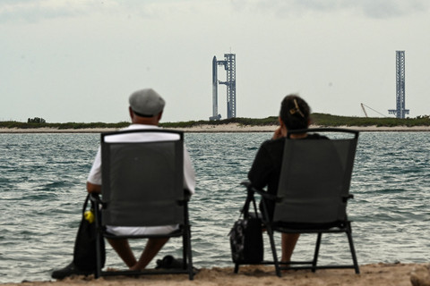 Orang-orang melihat roket SpaceX Starship di Starbase, Texas, seperti yang terlihat dari Pulau South Padre, Senin (25/8/2025).  Foto: Ronaldo Schemidt/AFP