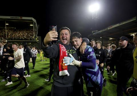 Kiper Grimsby Town Christy Pym berselebrasi bersama suporter usai mengalahkan Manchester United pada pertandingan ronde kedua Piala Liga Inggris di Blundell Park, Cleethorpes, Inggris, Rabu (28/8/2025). Foto: Lee Smith/Reuters