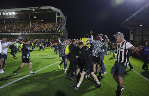 Sejumlah suporter klub sepak bola Grimsby Town masuk ke dalam lapangan saat berselebrasi usai mengalahkan Manchester United pada pertandingan ronde kedua Piala Liga Inggris di Blundell Park, Cleethorpes, Inggris, Rabu (28/8/2025). Foto: Lee Smith/Reuters