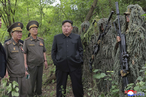 Pemimpin Korea Utara Kim Jong-un berdiri di samping para penembak jitu saat mengunjungi pangkalan pelatihan operasi di lokasi yang dirahasiakan dalam foto tanpa tanggal yang dirilis oleh Kantor Berita Pusat Korea resmi Korea Utara, Kamis (28/8/2025). Foto: KCNA via REUTERS