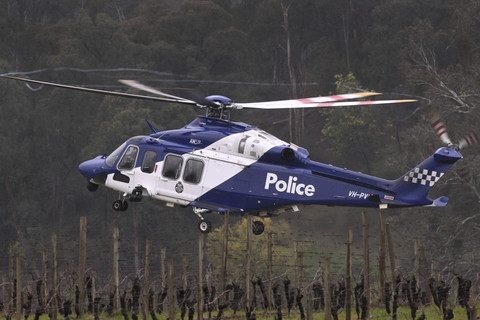 Sebuah helikopter polisi turut serta dalam pencarian di titik perhentian polisi dalam pencarian buronan terkait pembunuhan dua petugas polisi di Porepunkah, Australia, Kamis (28/8/2025). Foto: William West/AFP