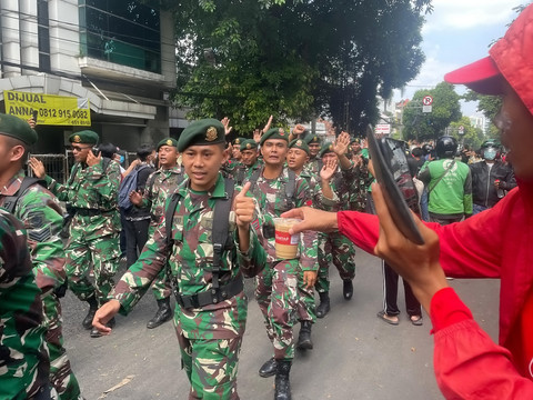 Massa aksi menyapa para TNI yang hadir saat demo di kawasan Mako Brimob Kwitang, Jakarta, Jumat (28/9/2025). Foto: Darryl Ramadhan/kumparan