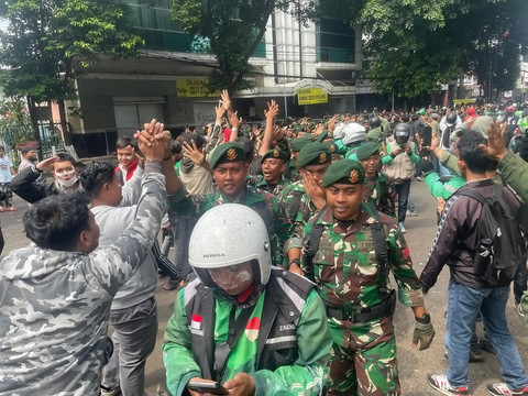 Massa aksi menyapa para TNI yang hadir saat demo di kawasan Mako Brimob Kwitang, Jakarta, Jumat (28/9/2025). Foto: Darryl Ramadhan/kumparan