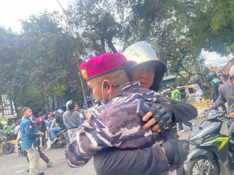 Seorang ojek online memeluk petugas TNI usai melakukan aksi di kawasan Mako Brimob Kwitang, Jakarta, Jumat (29/8/2025). Foto: Darryl Ramadhan/kumparan