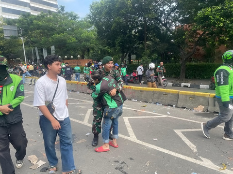 Seorang ojek online memeluk petugas TNI usai melakukan aksi di kawasan Mako Brimob Kwitang, Jakarta, Jumat (29/8/2025). Foto: Darryl Ramadhan/kumparan