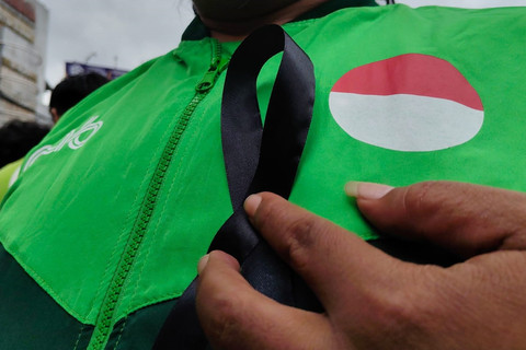 Ojol bagi-bagi pita hitam sebagai bentuk solidaritas untuk Affan Kurniawan, ojol yang dilindas rantis polisi saat demo di Jakarta di perempatan Condongcatur, Kabupaten Sleman, Jumat (29/8/2025). Foto: Arfiansyah Panji Purnandaru/kumparan