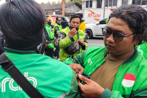 Ojol bagi-bagi pita hitam sebagai bentuk solidaritas untuk Affan Kurniawan, ojol yang dilindas rantis polisi saat demo di Jakarta di perempatan Condongcatur, Kabupaten Sleman, Jumat (29/8/2025). Foto: Arfiansyah Panji Purnandaru/kumparan