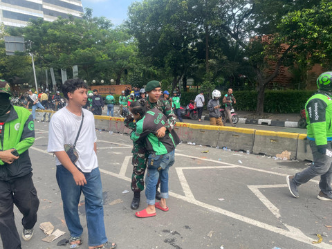 Seorang ojek online memeluk petugas TNI usai melakukan aksi di kawasan Mako Brimob Kwitang, Jakarta, Jumat (29/8/2025). Foto: Darryl Ramadhan/kumparan