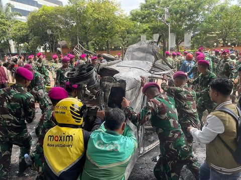 Sejumlah petugas TNI bersama massa aksi dan warga mengevakuasi kendaraan yang hangus terbakar saat aksi di kawasan Mako Brimob Kwitang, Jakarta, Jumat (29/8/2025).  Foto: Darryl Ramadhan/kumparan