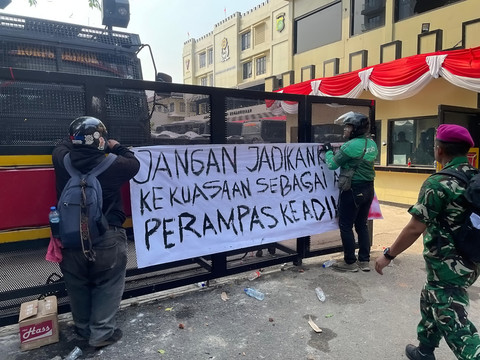 Massa membentangkan spanduk selama aksi di depan Gerbang Mako Brimob Kwitang, Jakarta, Jumat (8/29/2025). Foto: Darryl Ramadhan/Kumparan
