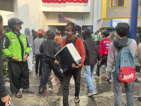 Massa aksi membawa barang-barang yang diambil dari gedung di belakang Halte Kramat Kwitang, Jakarta, Jumat (29/8/2025). Foto: Darryl Ramadhan/kumparan