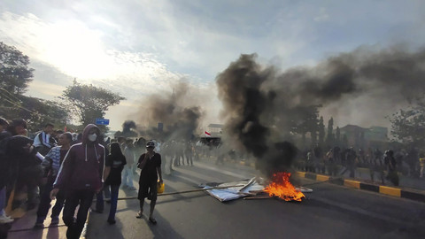 Sejumlah massa aksi membakar spanduk saat melakukan unjuk rasa di Kota Makassar, Sulawesi Selatan, Jumat (29/8/2025). Foto: kumparan