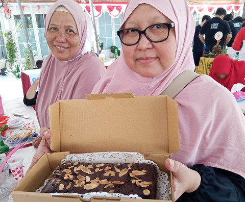 Pelaku UMKM di Kelurahan Wonorejo Rungkut, Surabaya, menunjukkan kue brownies kreasinya. Brownies ini dibuat dari tepung mangrove. Foto: Masruroh/Basra