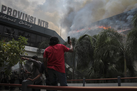 Warga mengambil gambar Gedung DPRD NTB yang terbakar saat aksi unjuk rasa di Mataram, NTB, Sabtu (30/8/2025). Foto: Dhimas Budi Pratama/ANTARA FOTO