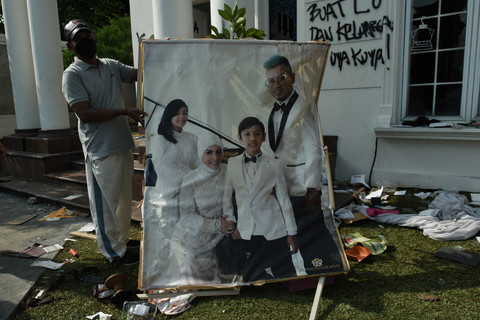 Massa menunjukkan bingkai foto yang rusak dari rumah Anggota DPR Surya Utama atau Uya Kuya di Pondok Bambu, Jakarta Timur, Minggu (31/8/2025). Foto: Fakhri Hermansyah/ANTARA FOTO