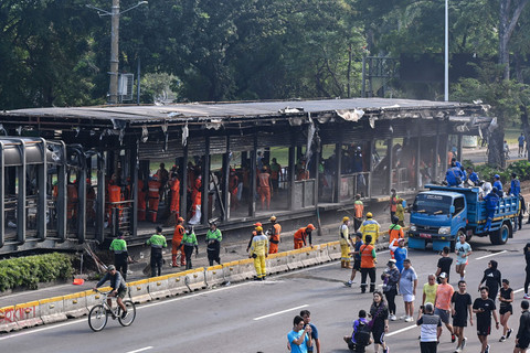 Petugas membersihkan puing-puing sisa terbakarnya Halte Polda Metro Jaya di Jalan Jenderal Sudirman, Jakarta, Minggu (31/8/2025). Foto: Sulthony Hasanuddin/ANTARA FOTO