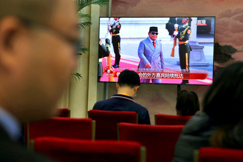 Layar TV menunjukkan Presiden Indonesia Prabowo Subianto tiba untuk parade militer yang menandai peringatan 80 tahun berakhirnya Perang Dunia Kedua, di ruang tunggu awak media di Beijing, Rabu (3/9/2025). Foto: Florence Lo/REUTERS