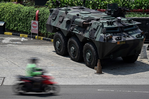 Seorang pengendara melintas di samping kendaraan taktis TNI jenis panser yang disiagakan di depan pusat perbelanjaan Glodok Harco, Jakarta, Selasa (2/9/2025). Foto: Fauzan/ANTARA FOTO