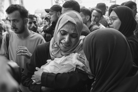 Seorang perempuan Palestina menangis sambil menggendong jenazah bayi yang tewas dalam serangan Israel di Kota Gaza saat fajar, sebelum prosesi pemakaman di luar rumah sakit Al-Shifa, Kamis (4/9/2025). Foto: OMAR AL-QATTAA/AFP