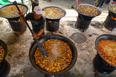 Para pria menyiapkan hidangan kari tradisional untuk warga dalam rangka memperingati Maulid Nabi Muhammad SAW, di Krueng Barona Jaya, pinggiran Banda Aceh, pada 6 September 2025. Foto: Chaideer Mahyuddin / AFP