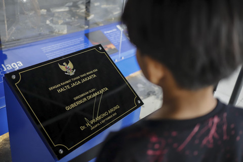 Warga melihat tanda tangan peresmian di halte bus Transjakarta Jaga Jakarta di kawasan Senen, Jakarta Pusat, Senin (8/9/2025). Foto: Jamal Ramadhan/kumparan