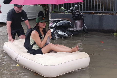 Derk (laki-laki, 50 tahun), wisatawan asal Afrika Selatan tampak menikmati momen mendorong istrinya yang duduk santai di matras angin di tengah banjir di Jalan Dewi Saraswati III, Kelurahan Seminyak, Kabupaten Badung, Bali, Rabu (10/9/2025) Foto: Denita BR Matondang/kumparan