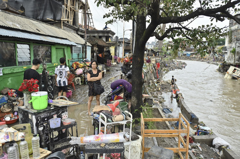Warga berjalan di dekat bangunan rumah yang diterjang banjir di kawasan Jalan Bukit Barisan, Denpasar, Bali, Rabu (10/9/2025). Foto: Fikri Yusuf/ANTARA FOTO