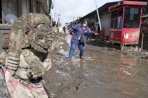 Warga berjalan melewati lumpur pasca terjadi banjir di Pasar Kumbasari, Denpasar, Bali, Kamis (11/9/2025). Foto: Nyoman Hendra Wibowo/ANTARA FOTO