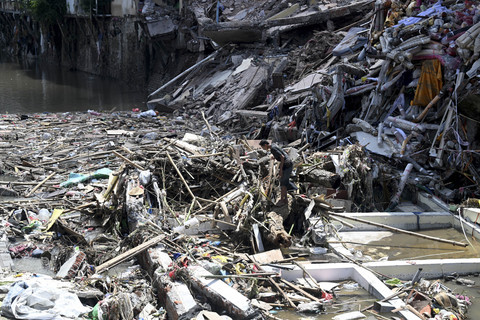 Seorang warga mencari barangnya yang hanyut pascabanjir di Denpasar, Bali, Jumat (12/9/2025). Foto: Sonny Tumbelaka/AFP