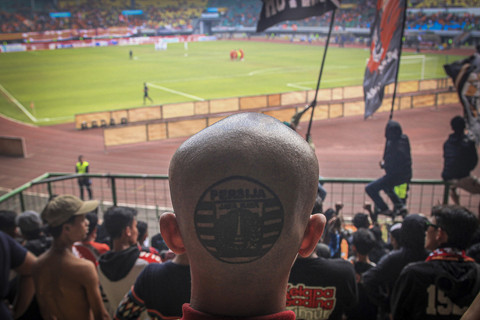 Tato bergambar logo Persija Jakarta yang dibuat di kepala seorang Jakmania. Foto: Darryl Ramadhan/kumparan