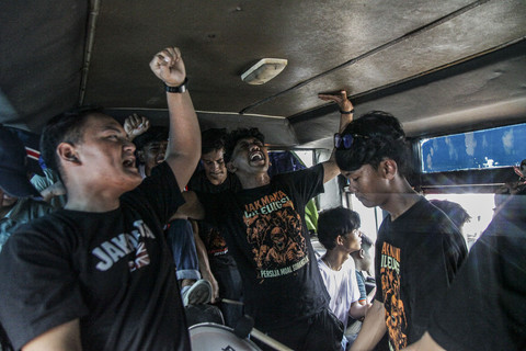 Siap Dukung Persija: Sejumlah suporter Persija Jakarta, Jakmania menyanyikan yel-yel di dalam bus saat berangkat menyaksikan pertandingan Persija Jakarta. Foto: Darryl Ramadhan/kumparan