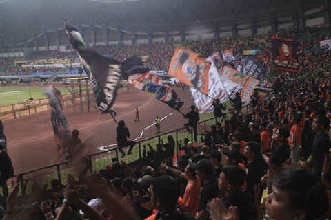 Sejumlah Jakmania mengibarkan bendera saat menyaksikan pertandingan Persija Jakarta di Stadion Patriot Candrabhaga, Bekasi, Jawa Barat.  Foto: Darryl Ramadhan/kumparan