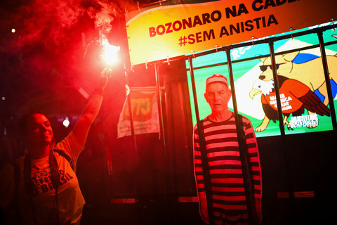 Warga memegang kembang api saat menghadiri pesta karnaval untuk merayakan vonis mantan presiden Brasil Jair Bolsonaro. Foto: REUTERS/Tita Barros