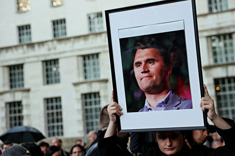 Seorang pria memegang foto Charlie Kirk, saat orang-orang menghadiri acara peringatan di Patung Montgomery di Whitehall, untuk mengenang aktivis konservatif AS, Charlie Kirk, London, Inggris (12/9/2025). Foto: Jack Taylor/Reuters