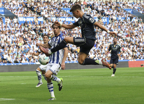 Arda Guler dari Real Madrid beraksi bersama Aritz Elustondo dari Real Sociedad pada pertandingan Liga Spanyol antara Real Sociedad v Real Madrid di Reale Arena, San Sebastian, Spanyol, Sabtu (13/9/2025). Foto: PANKRA NIETO/REUTERS
