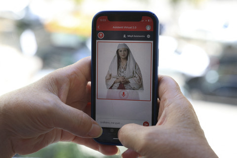 Seorang perempuan sedang menggunakan ponselnya saat menggunakan portal pemerintah Albania "E - Albania", yang kini dibantu oleh avatar menteri kabinet kecerdasan buatan pemerintah "Diella", di Tirana, Albania, Jumat 912/9/2025). Foto: Adnan Beci/AFP