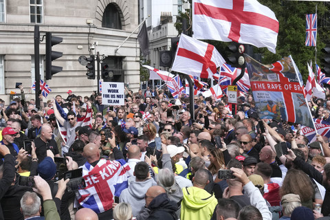 Aktivis sayap kanan Inggris Tommy Robinson menyapa para pendukungnya saat mereka berjalan mengibarkan bendera Union dan St George's Cross di pusat kota London dalam pawai "Kebebasan Berbicara" pada Sabtu (13/9/2025). Foto: Carlos Jasso/REUTERS